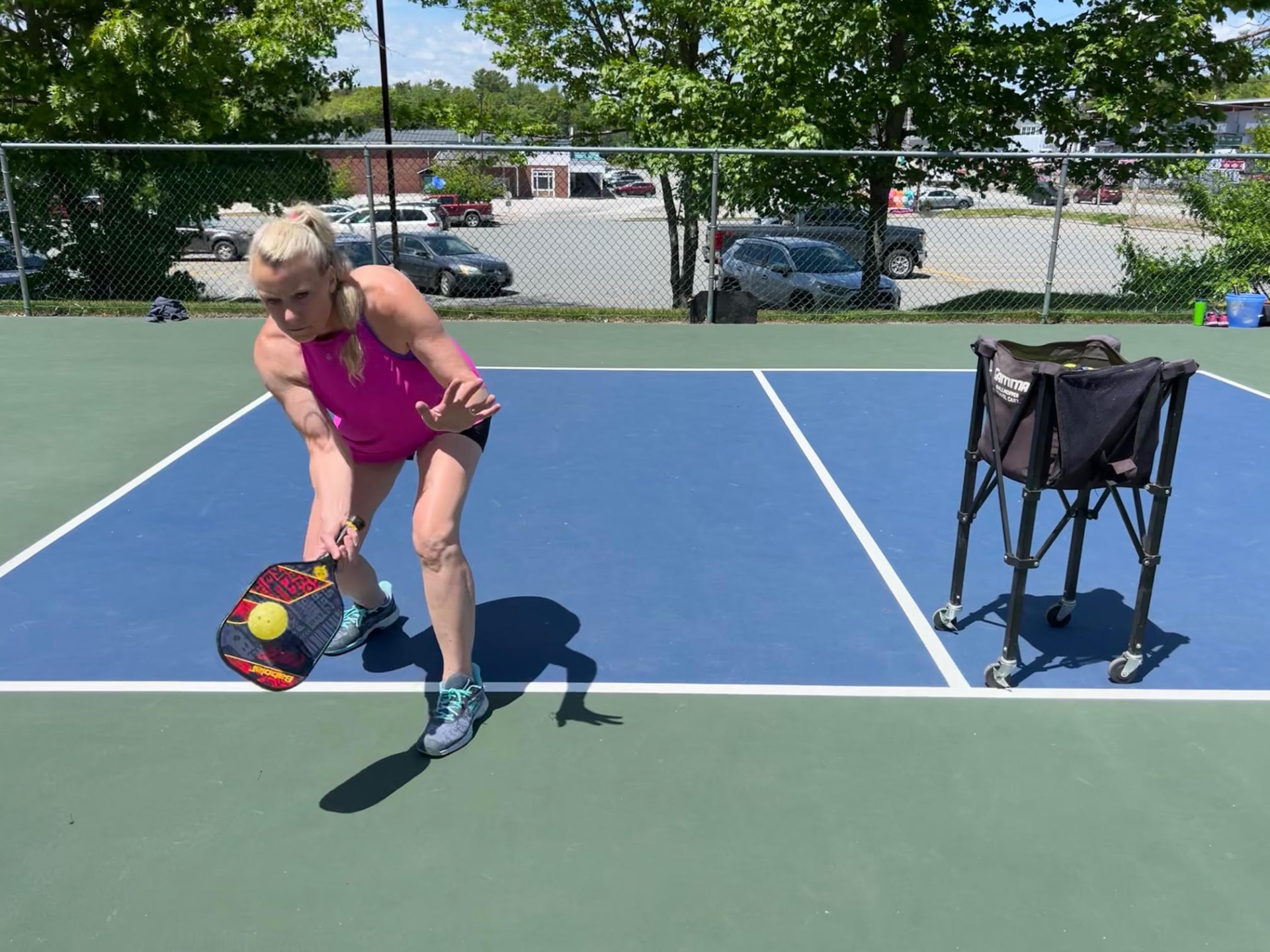 Lisa Palcic demonstrating a low forehand stroke on a pickleball court